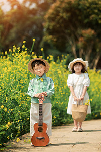 开心男孩摄影照片_手拿吉他的男孩和小女孩摄影图配图