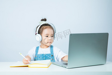 带发箍小女孩摄影照片_线上教育白天小女孩室内操作电脑摄影图配图