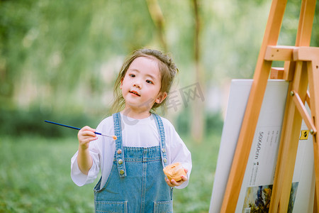 儿童启蒙摄影照片_艺术启蒙白天写生的小女孩户外草坪画画摄影图配图