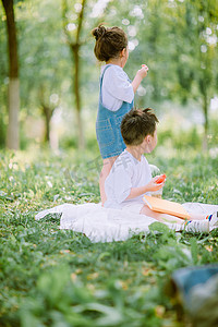 小朋友手拉手画摄影照片_童趣夏天两个小朋友户外树林背影摄影图配图