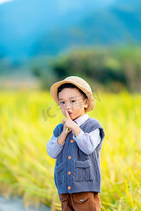 在水稻前嘘嘴的男孩摄影图配图