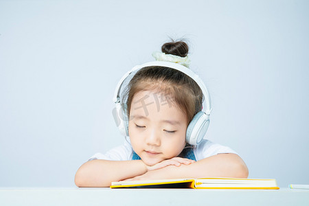 趴在阳台的小孩摄影照片_线上教育减负白天上课的小女孩室内趴在桌上睡觉摄影图配图