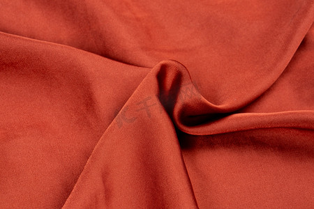 桑蚕丝花纹摄影照片_纺织品布料纹理褶皱桑蚕丝橙红色摄影图配图