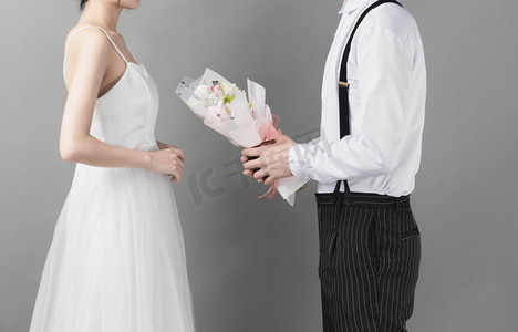 结婚新人摄影照片_婚礼白天新郎新娘室内鲜花摄影图配图