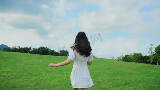 唯美清新蓝天白云下女生在草坪上奔跑背影