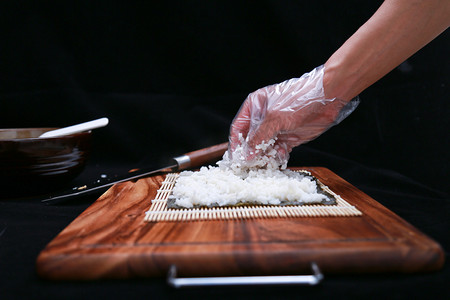 厨具摄影照片_厨房正在制作寿司美食的手部特写摄影图配图