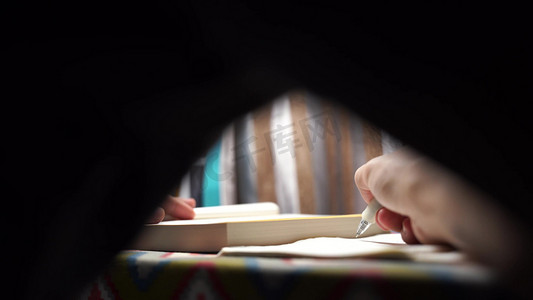深夜灯光下伏案学习的男生特写实拍