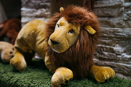 狮子卡通狮子摄影照片_儿童动物玩具狮子晚上狮子玩偶室内摄影摄影图配图