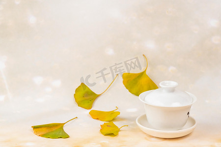 唯美清新秋天摄影照片_秋季白天银杏树叶室内茶碗摄影图配图