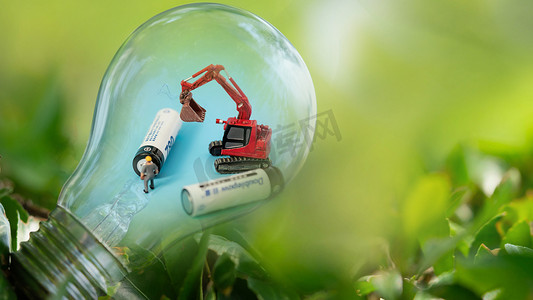 泡泡单车摄影照片_绿色环保节能电池白天灯光电池草地发光摄影图配图