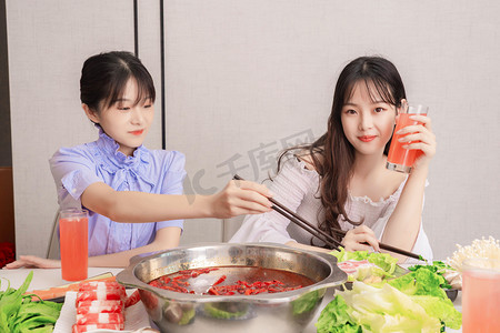 餐饮火锅摄影照片_聚会白天美女餐厅涮火锅摄影图配图
