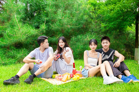 野餐早上青年学生户外草坪摄影图配图