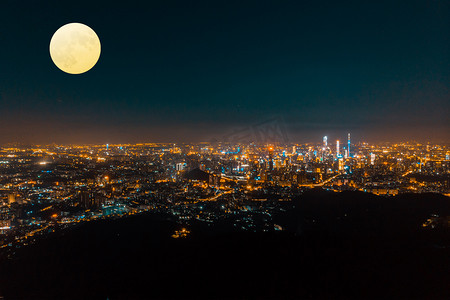 中秋节月亮圆月摄影照片_中秋节晚上城市建筑户外明月摄影图配图