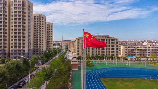 操场跑步摄影照片_学校白天五星红旗操场跑步摄影图配图