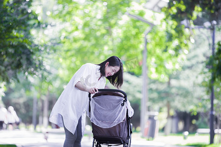 照顾孩子摄影照片_母亲人像家庭婴儿车宝宝摄影图配图