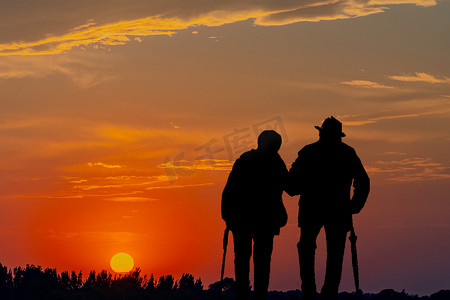 剪影黄昏老人户外牵手摄影图配图