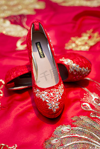 婚中式婚礼红色摄影照片_婚礼红色婚鞋结婚高跟鞋摄影图配图