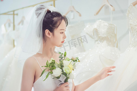 粉紅色礼服摄影照片_婚纱白天鲜花新娘室内婚纱店摄影图配图