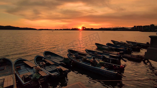 夕阳海摄影照片_夕阳下渔民在渔船上工作实拍