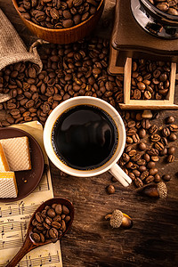 咖啡饮料摄影照片_美食夜晚咖啡咖啡豆甜点室内木桌上摄影图配图