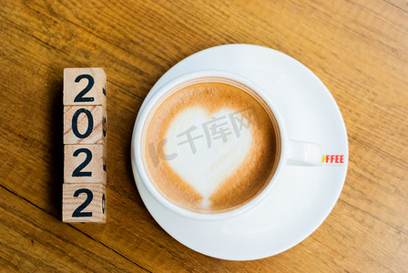新年快乐2022年摄影照片_咖啡2022年一杯咖啡摆放在桌子上摄影图配图
