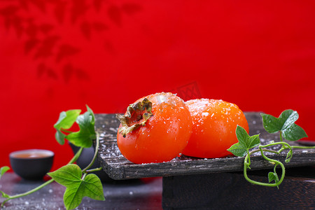 迷彩柿子摄影照片_水果秋收柿子红柿子红色背景摄影图配图