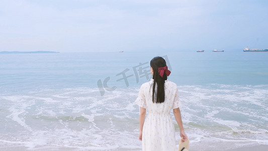 海洋展架摄影照片_海滩上的白衣美女背影