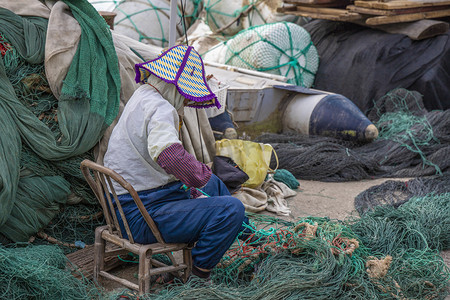 打渔的人摄影照片_补网的渔民下午人岛上无摄影图配图