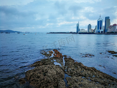 青岛海边礁石天际线白天阴天大海礁石大海风光摄影图配图