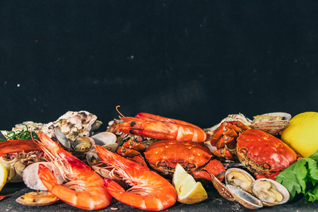 海鲜大杂烩白天大虾螃蟹室内柠檬摄影图配图