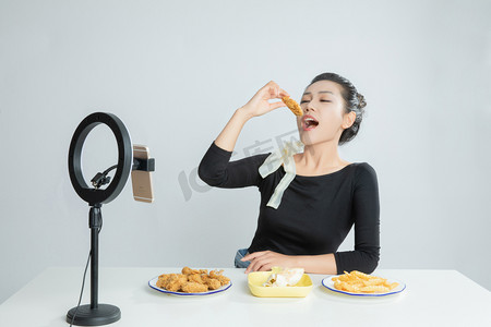 吃货节美食摄影照片_吃播美食主播直播吃鸡块平拍摄影图配图