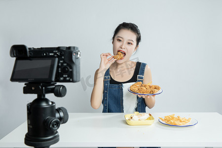 吃货节美食摄影照片_直播设备前吃美食的主播平拍摄影图配图