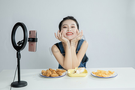 吃货节摄影照片_手捧脸颊的美食主播平拍摄影图配图