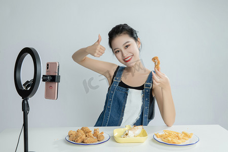 517吃货节摄影照片_直播间直播吃美食的美女平拍摄影图配图