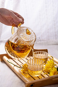 茶白天茶壶木桌倒茶摄影图配图