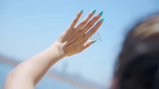 推开门再见招手摄影照片_美女挥手摸天空阳光特写意境