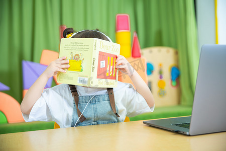 儿童教育白天小女孩教室用书挡住脸摄影图配图