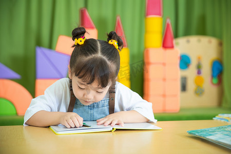 儿童勾线摄影照片_儿童生活白天可爱小女孩教室读书摄影图配图