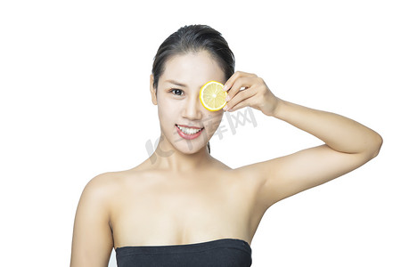 美容护肤白天年轻美女室内用柠檬片挡眼睛摄影图配图