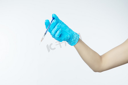 医美微整形白天戴手套的手室内手拿注射器摄影图配图