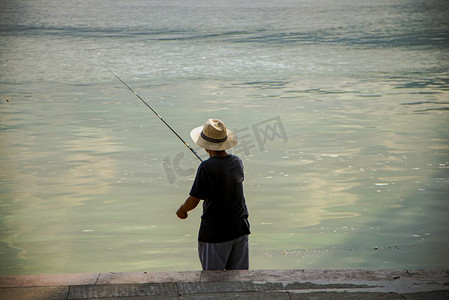 英德仙湖摄影照片_英德北江男士在江边垂钓摄影图配图