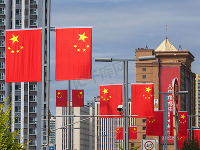 共青团红旗摄影照片_国庆节城市街道国旗白天红旗城市飘扬摄影图配图