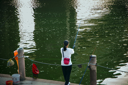 英德北江一名女性在江边垂钓摄影图配图