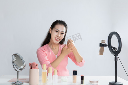 美妆主播直播化妆在手上试化妆水乳效果摄影图配图