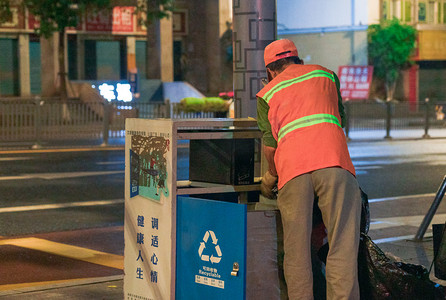 环卫工人清扫垃圾桶摄影图清晨环卫工人公路扫垃圾桶摄影图配图