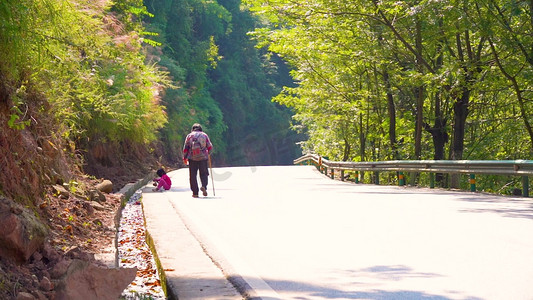 山间公路行走的老人背影意境