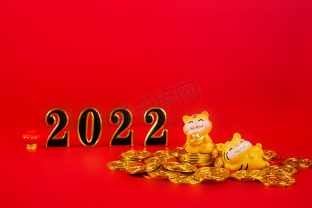 春节金币摄影照片_新年2022老虎摆件红色背景摆放摄影图配图