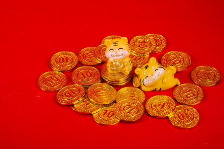 春节虎年两个老虎玩偶金币堆躺着摄影图配图