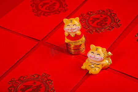 老虎红包摄影照片_春节两个老虎玩偶红包坐着摄影图配图