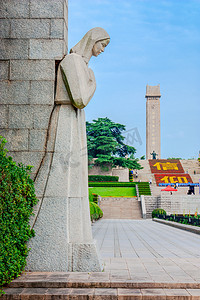 革命清明摄影照片_南京雨花台烈士陵园雕塑与远处的纪念碑摄影图配图